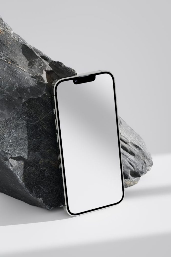 Close-up of a smartphone against a stone background, emphasizing modern design.